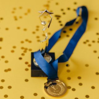 A Medal and a Trophy on Yellow Surface